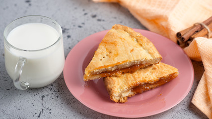 homemade cake with jam and a Cup of milk on the table