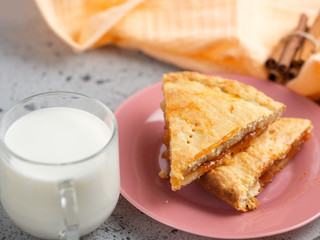 homemade cake with jam and a Cup of milk on the table