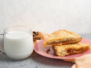 homemade cake with jam and a Cup of milk on the table