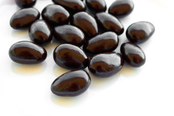 Chocolate candies with almond on white background