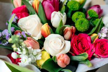bouquet of tulips and roses. orange, green, white and red flowers. close up
