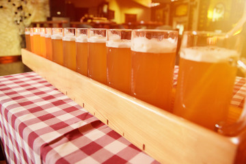 A very large tray with glasses of beer on the table