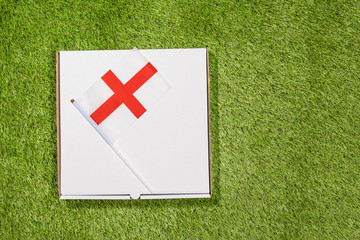 Paper box of pizza with English Flag  on the grass. Concept. Top view