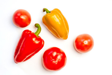  yellow and red peppers and tomatoes on a white background