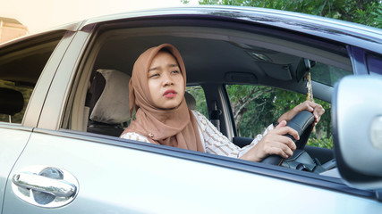 portrait of young Muslim hijab women while driving a car looking forward