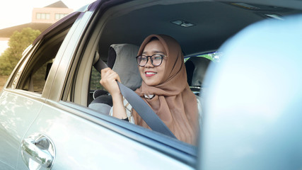 portrait of a Muslim hijab woman wearing her seat belt