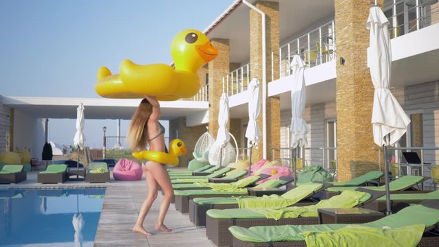 summer leave, attractive slender girl with long hair and beautiful booty spends fun time with happy vacation at the pool at sunny day at luxury resort