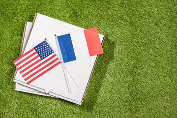 Paper box of pizza with American and flag of France on the grass. Concept of peace, partnership and friendship, . Top view