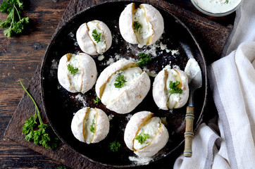 Whole baked potatoes with curd sauce and herbs