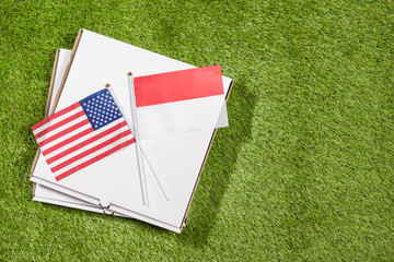 Paper box of pizza with flags of America and indonesia on the grass. Concept of peace, partnership and friendship, . Top view