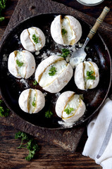 Whole baked potatoes with curd sauce and herbs