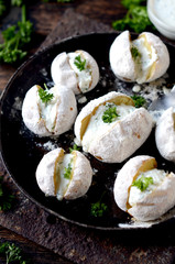 Whole baked potatoes with curd sauce and herbs