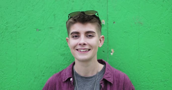 Portrait of gender neutral young adult with green background