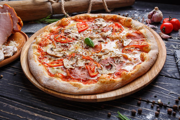 Pizza with vegetables, mushrooms, ham and mozzarella