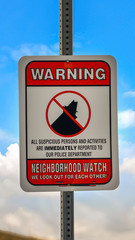 Vertical frame Close up of a Warning sign on a neighborhood against cloudy blue sky background