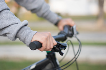 close up shot of hijab  woman's hand was holding the wheel of a bicycle in a park