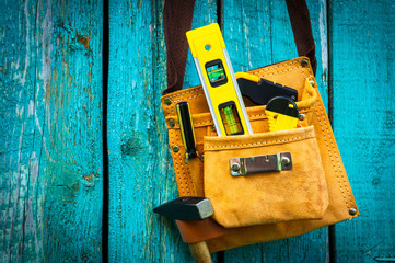 Tools in the bag for homework on the old wooden background.