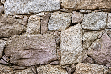 Detail of an old stone wall arranged in an irregular manner. Architecture constructions. Vintage background.