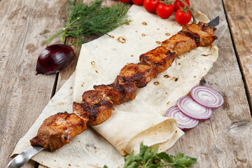 various barbecue skewers on a wooden table
