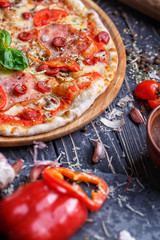 Spicy pizza with hunting sausages, ham and mushrooms