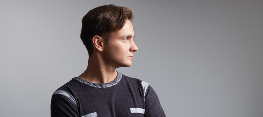 Profile portrait of a handsome man isolated on grey background