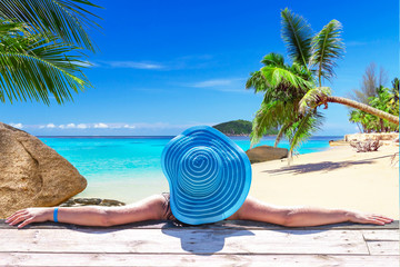 Fototapeta na wymiar Woman in hat on tropical holidays at the beach