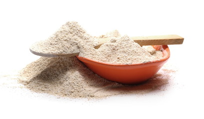 Barley flour pile with wooden spoon and porcelain bowl isolated on white background
