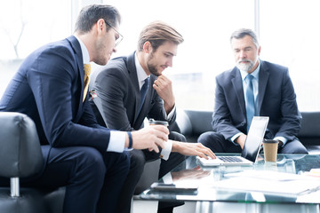 Group of business partners discussing ideas and planning work in office.