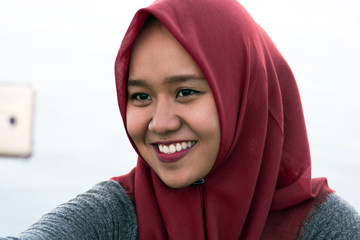 close-up shot of photos of hijab women selfie facing the camera while laughing