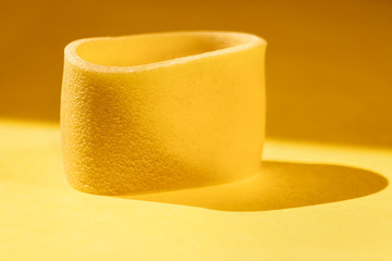 Italian pasta calamarata on colored background