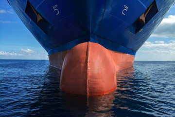 Close up of large blue merchant crago ship in the middle of the ocean underway. Performing cargo...