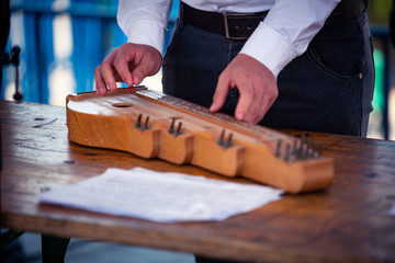 Fingers playing on traditional music instrument zither