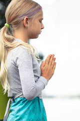 portrait of Blond caucasian girl in namaste. Close-up of yoga girl hands in namaste gesture outdoor summer day