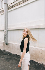 young blond woman walking on the old street