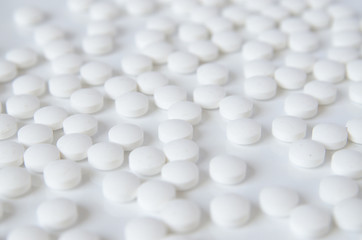Fototapeta na wymiar scattered white pills on the white table