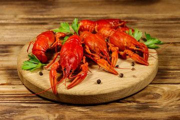 Boiled crayfish on cutting board on wooden table