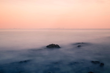 Long exposure of the waves that cover the rocks in the sea and the beautiful colors of the sky in dusk looks like a dream.