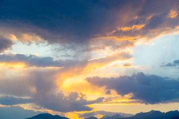 Naklejka premium soft sunset sky. pink and gold clouds. High mountains. Natural background.