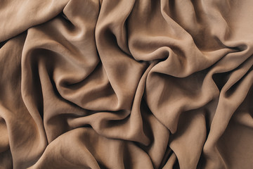 Brown silk crumpled linen blanket texture pattern. Closeup textile background.
