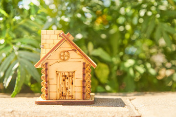 Obraz na płótnie Canvas mini toy wooden house on summer nature background. concept of mortgage, construction, rental, using as family and property concept. copy space