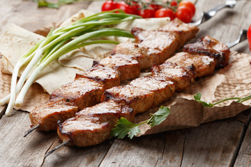 pork skewers on a wooden table, selective focus