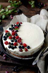 Cheesecake with fresh berries on a dark wooden background