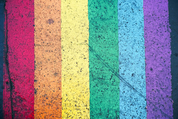 Road marking of pedestrian crossing and rainbow flag in Paris. Sex discrimination concept. Selective focus. The symbol of the LGBT community, equal rights