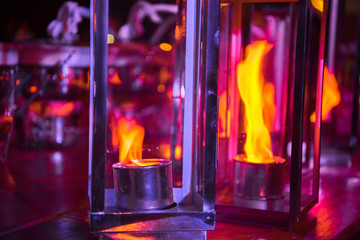 Glass lamps with a real fire inside in purple tones. Night photo.