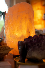 Himalayan salt lamp on wooden table illuminated 