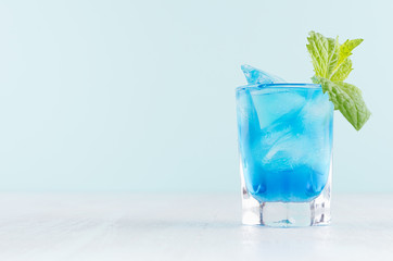 Exquisite blue cocktail for celebration in beach style with blue curacao, ice cube, green mint in...