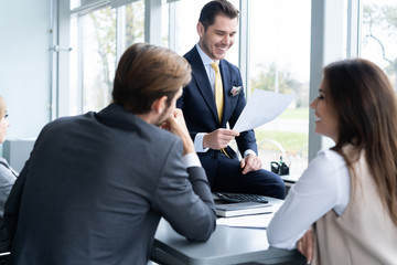 Businesspeople discussing together in conference room during meeting at office.