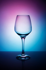 Wine glass on a purple white blue background.