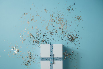 Present on blue background with silver confetti.