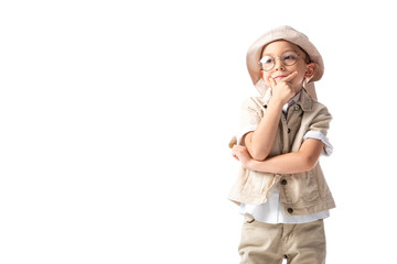 pensive explorer boy in glasses and hat touching chin and looking away isolated on white
